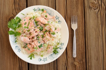 Salmon with rice, scallion and cilantro in white plate with fork