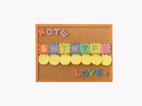 A cork notice board with empty post it for everyday in a week with starting text of day and love word at the bottom of board.