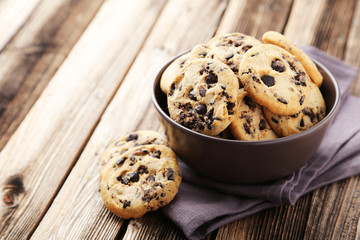 Chocolate chip cookies in bowl on brown wooden background - obrazy, fototapety, plakaty