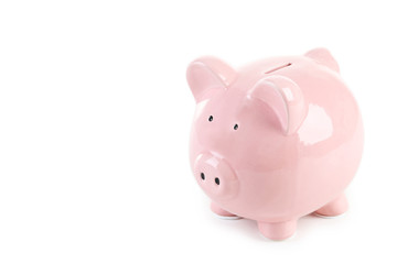 Pink piggy bank with glasses on white wooden background