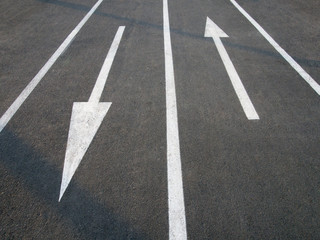 Fototapeta premium Directional arrow signs on the asphalt road.