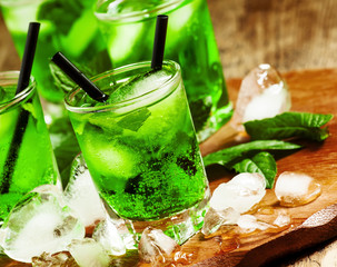Green cocktail with mint, ice and soda, selective focus