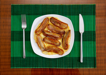 Deep fried bananas with scrambled eggs on white plate