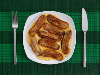 Deep fried bananas with scrambled eggs on white plate