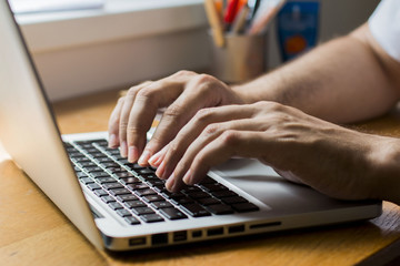 Close up hands, man using laptop
