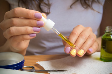Female hand holding a pipette with oil