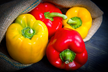 red and yellow pepper on burlap sack on wooden