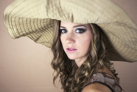 Beautiful young woman wearing big sun hat