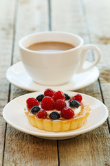 Cake with berries and cup of coffee