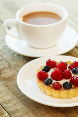 Cake with berries and cup of coffee