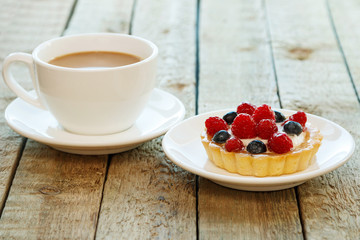 Cake with berries and cup of coffee