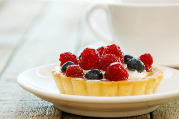 Cake with berries and cup of coffee