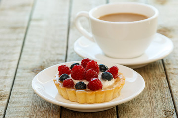 Cake with berries and cup of coffee