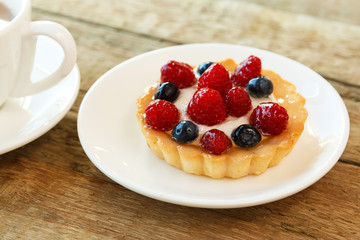 Cake with berries and cup of coffee
