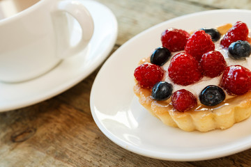 Cake with berries and cup of coffee