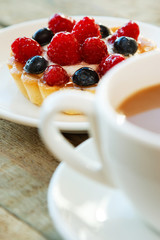 Cake with berries and cup of coffee