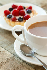 Cake with berries and cup of coffee