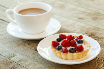 Cake with berries and cup of coffee