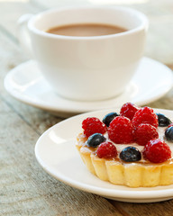 Cake with berries and cup of coffee