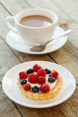 Cake with berries and cup of coffee