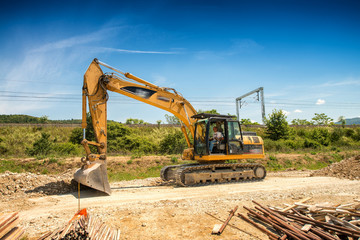 Fototapeta na wymiar Big excavator on new construction site, in the background the bl