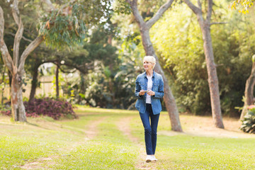 middle aged woman walking at the park - 85067707
