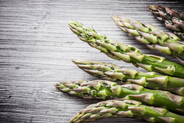 Raw, fresh asparagus on gray wood.