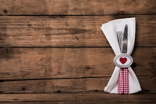 Fest der Liebe: Besteck in rot weiß kariert mit Serviette auf Holz