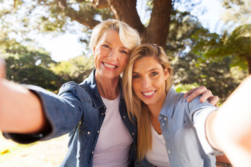 senior woman and daughter taking selfie - obrazy, fototapety, plakaty