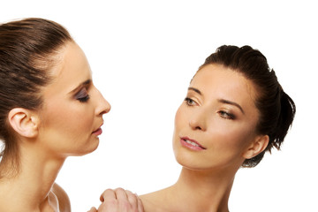 Two sisters with make up looking at each other.