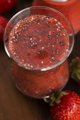Glass of red strawberry smoothie with chia seeds