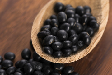 A lot of black soybeans on wooden background