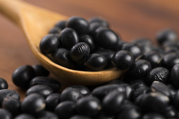 A lot of black soybeans on wooden background