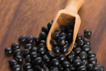 A lot of black soybeans on wooden background