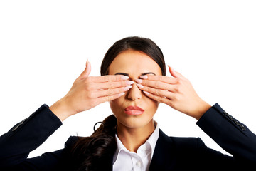Businesswoman covering eyes with hands