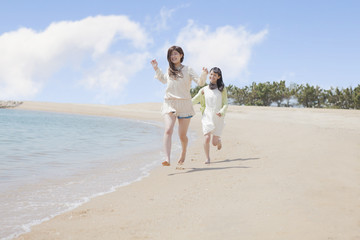 Fototapeta na wymiar 海辺で遊ぶ女の子たち