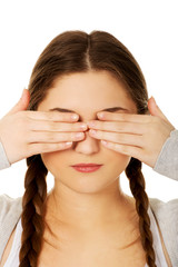 Teen woman covering her eyes.