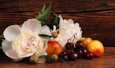 Peony, cherry and peach. Still life with fresh berries and flowers.