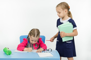 Girl teacher stands at the student desk