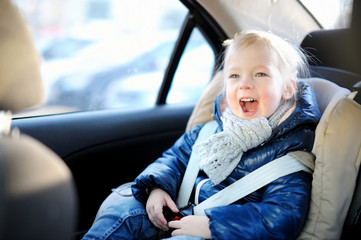 Adorable little girl sitting in a car seat