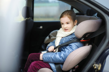 Adorable little girl sitting in a car seat