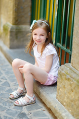 Adorable little girl sitting on a doorstep © MNStudio