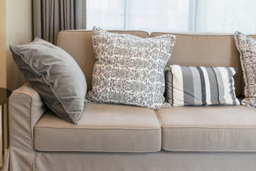 Fototapeta na wymiar Sturdy brown tweed sofa with grey patterned pillows