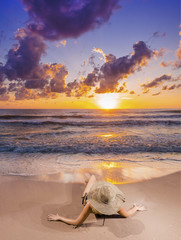 Fototapeta na wymiar Young woman watching as sun sets over Bali