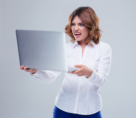 Businesswoman with disgusted emotion holding laptop