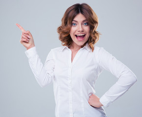 Cheerful businesswoman pointing finger away