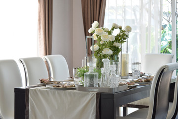 dining wooden table and comfortable chairs in modern home with e
