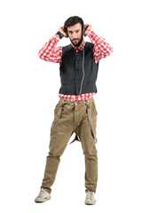 Naklejka premium Confident young hipster holding earphones listening to music