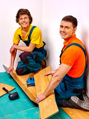 Men laying parquet at home