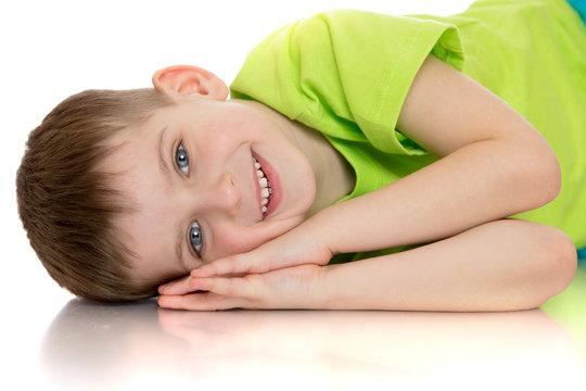 Smiling little boy lying on the floor placing your hands under y